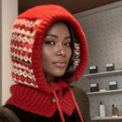 NEWYORKLISTED STYLE COLLECTION: Drawstring Knitted Winter Hat – Cozy, Chic & Cold-Weather Ready: Person wearing a red knitted hood with a patterned interior in a store setting