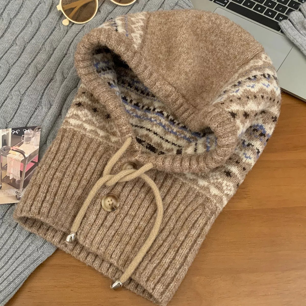 NEWYORKLISTED STYLE COLLECTION: Drawstring Knitted Winter Hat – Cozy, Chic & Cold-Weather Ready: Brown knitted sweater with a hood on a wooden surface