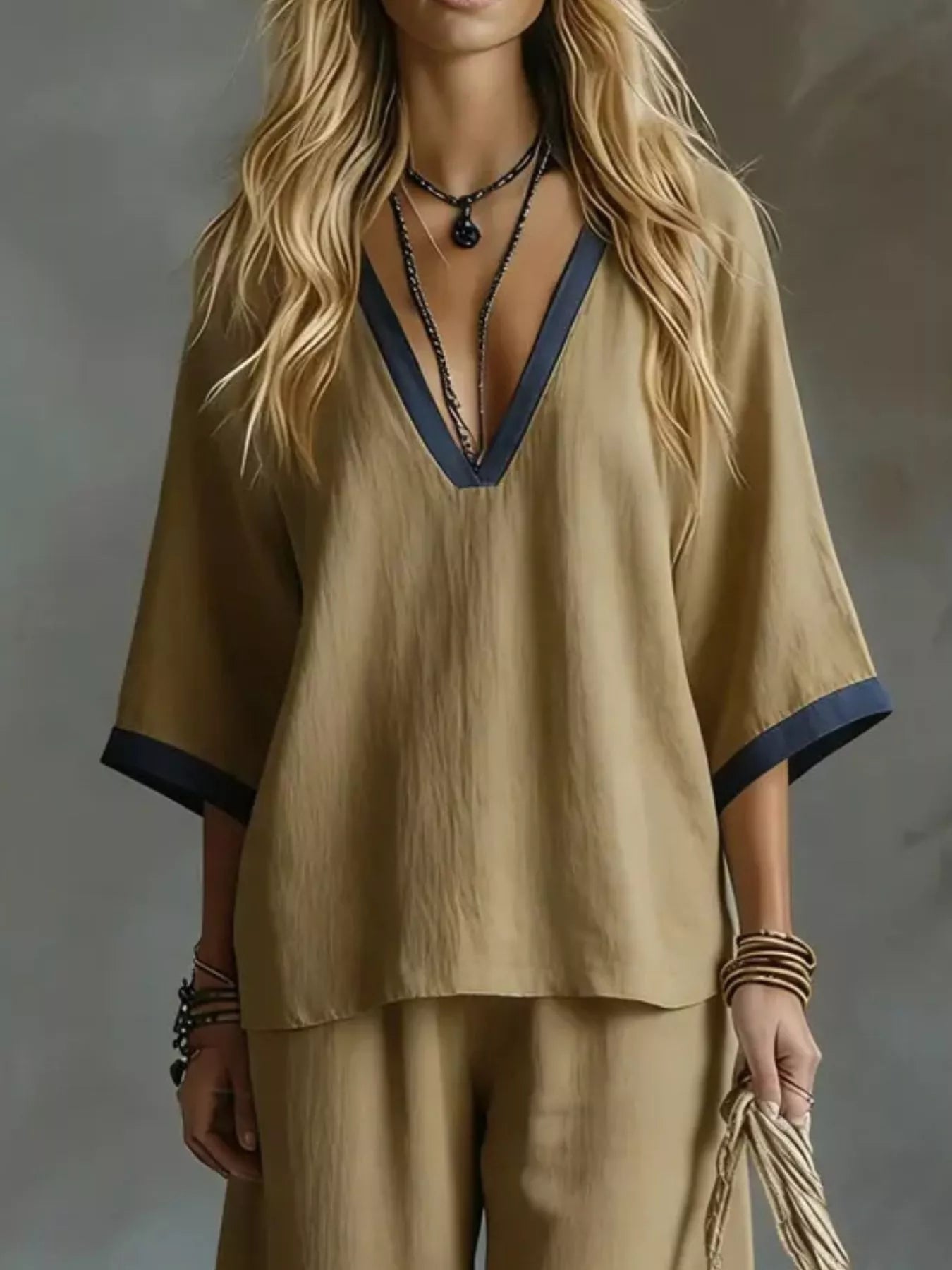 NEWYORKLISTED STYLE COLLECTION: Woman wearing a beige outfit with a deep neckline against a gray background