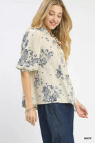 NEWYORKLISTED STYLE COLLECTION: Woman wearing a floral blouse with navy accents on a white background