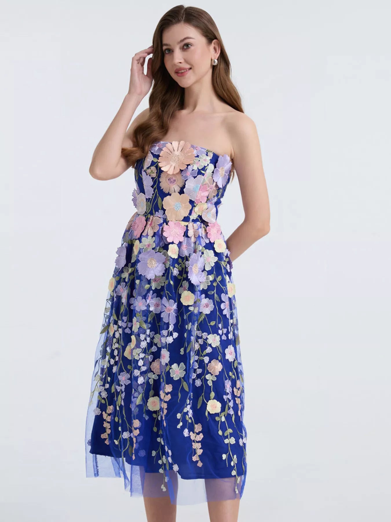 NEWYORKLISTED STYLE COLLECTION: Woman wearing a strapless floral dress on a white background