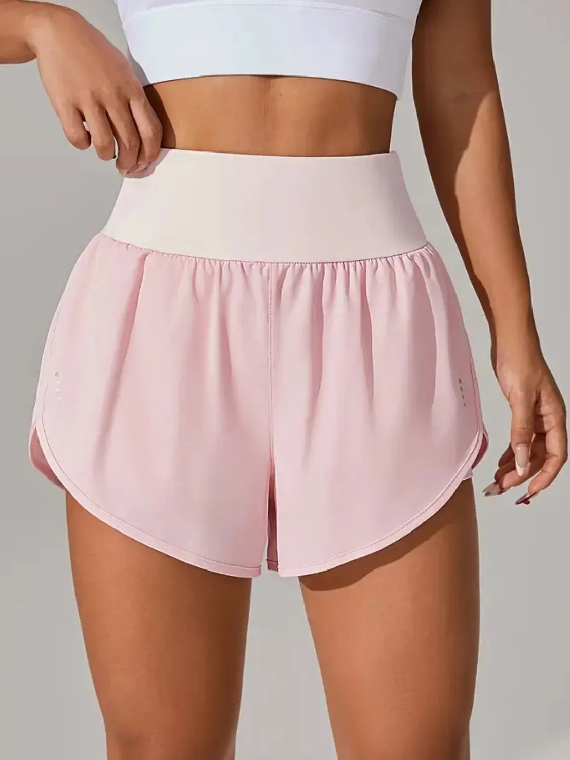 NEWYORKLISTED Activewear: Person wearing pink athletic shorts and a white top on a plain background