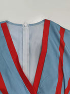 NEWYORKLISTED STYLE COLLECTION: Close-up of a garment with red and blue stripes on a plain background