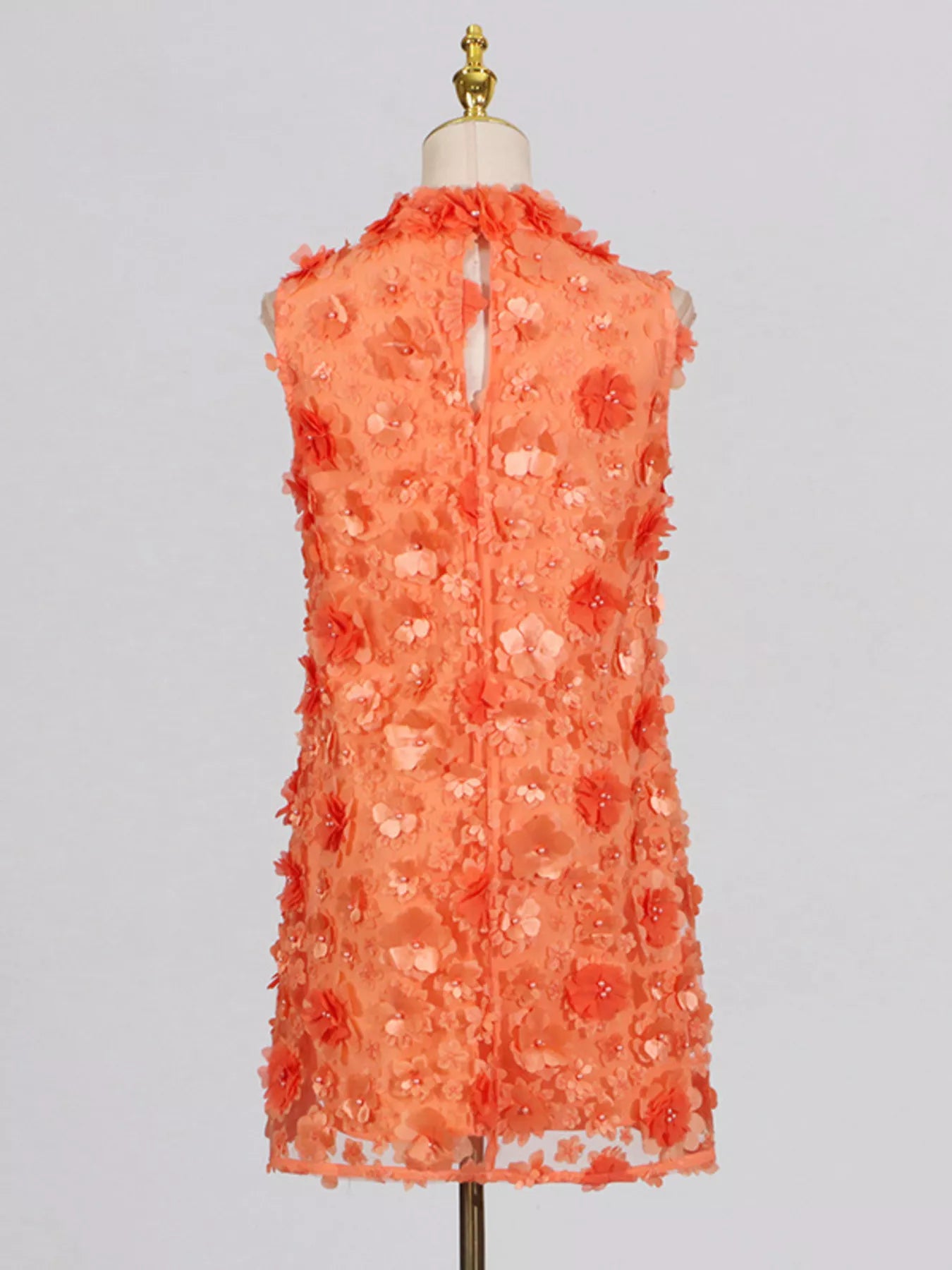 NEWYORKLISTED STYLE COLLECTION: Coral floral dress on a mannequin against a light gray background
