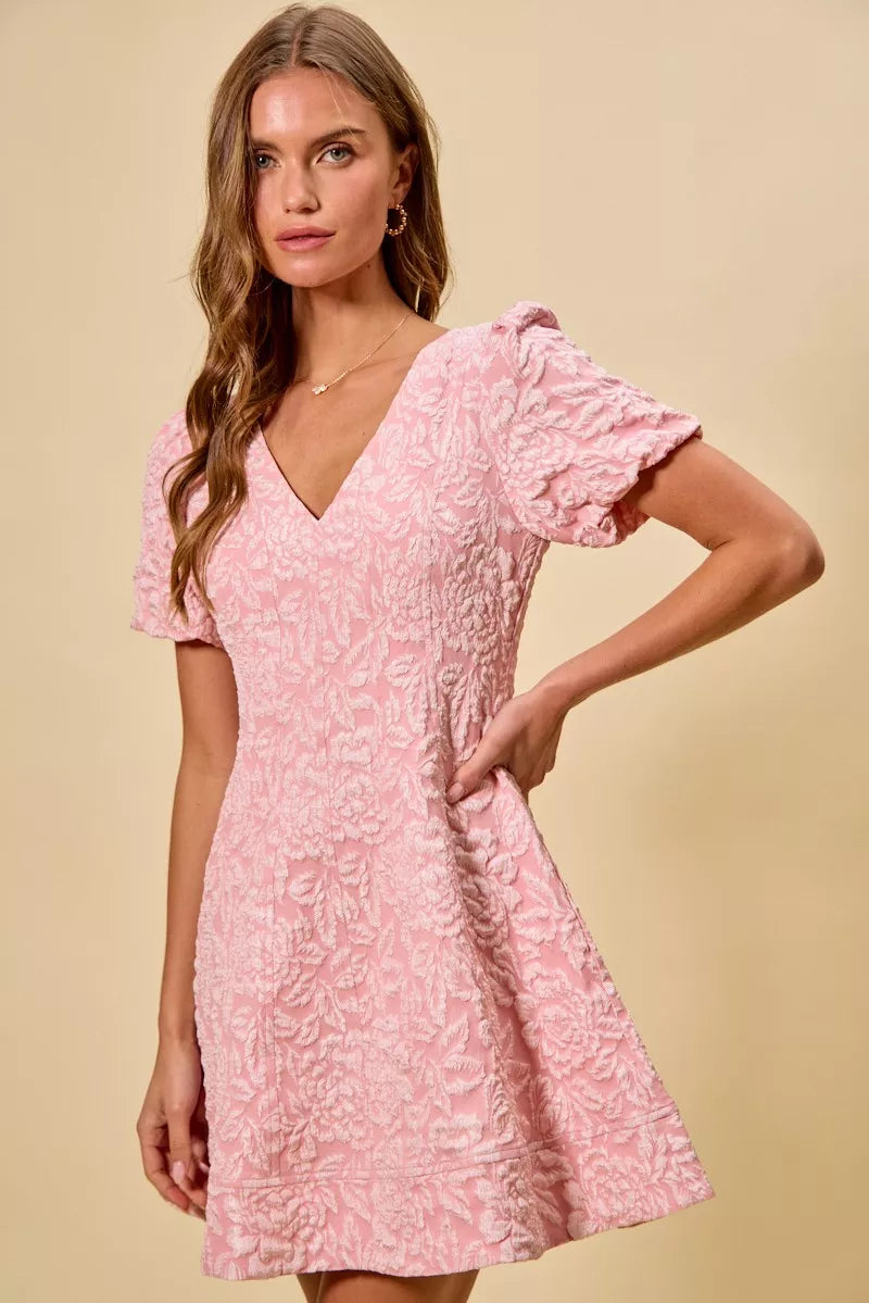 NEWYORKLISTED STYLE COLLECTION: Woman wearing a pink floral dress against a beige background