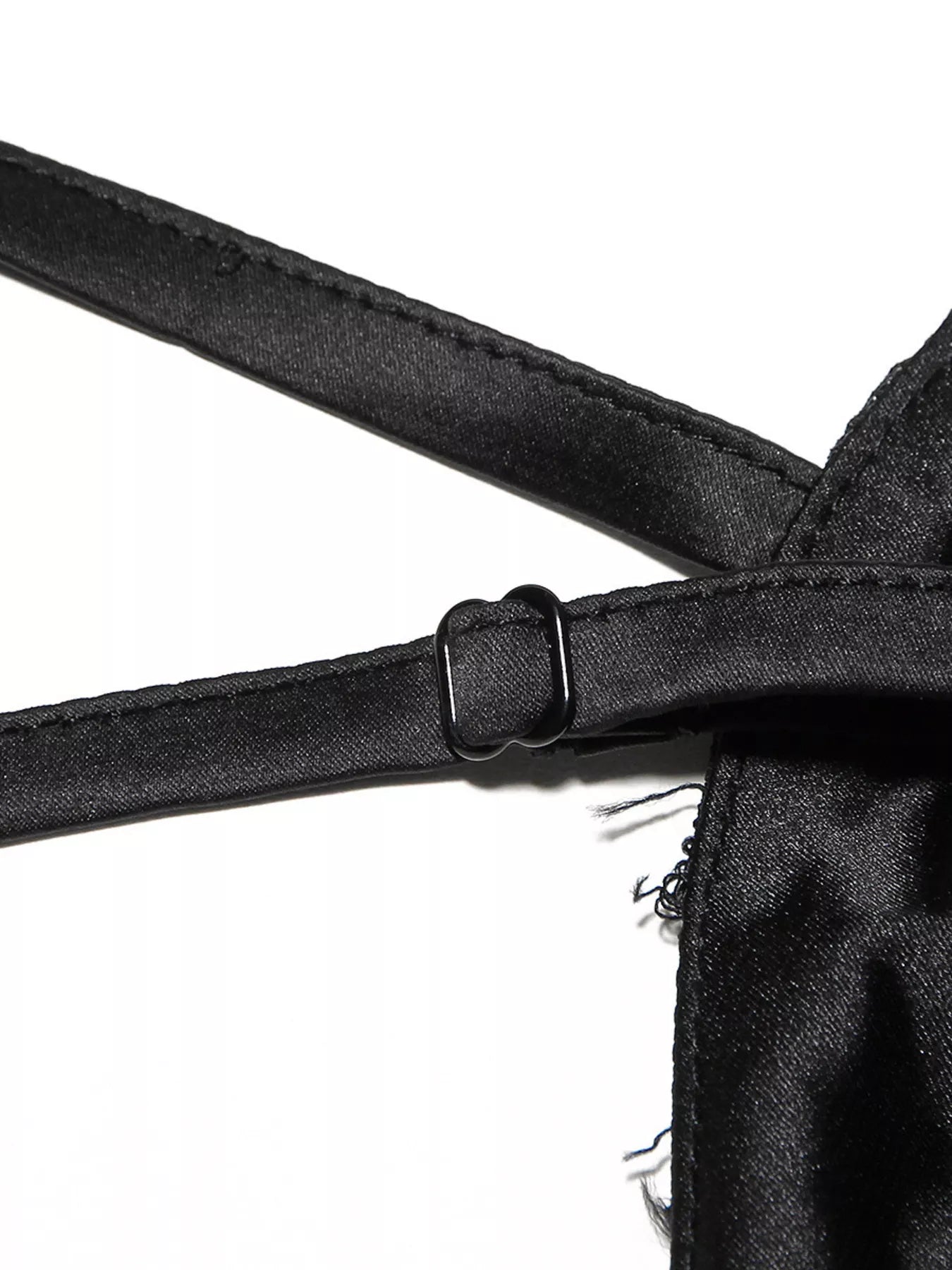 NEWYORKLISTED STYLE COLLECTION: Close-up of a black satin garment with straps on a white background