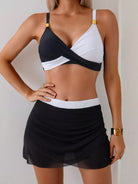 NEWYORKLISTED EDEN COLLECTION: Woman wearing a black and white bikini with a matching skirt against a neutral background