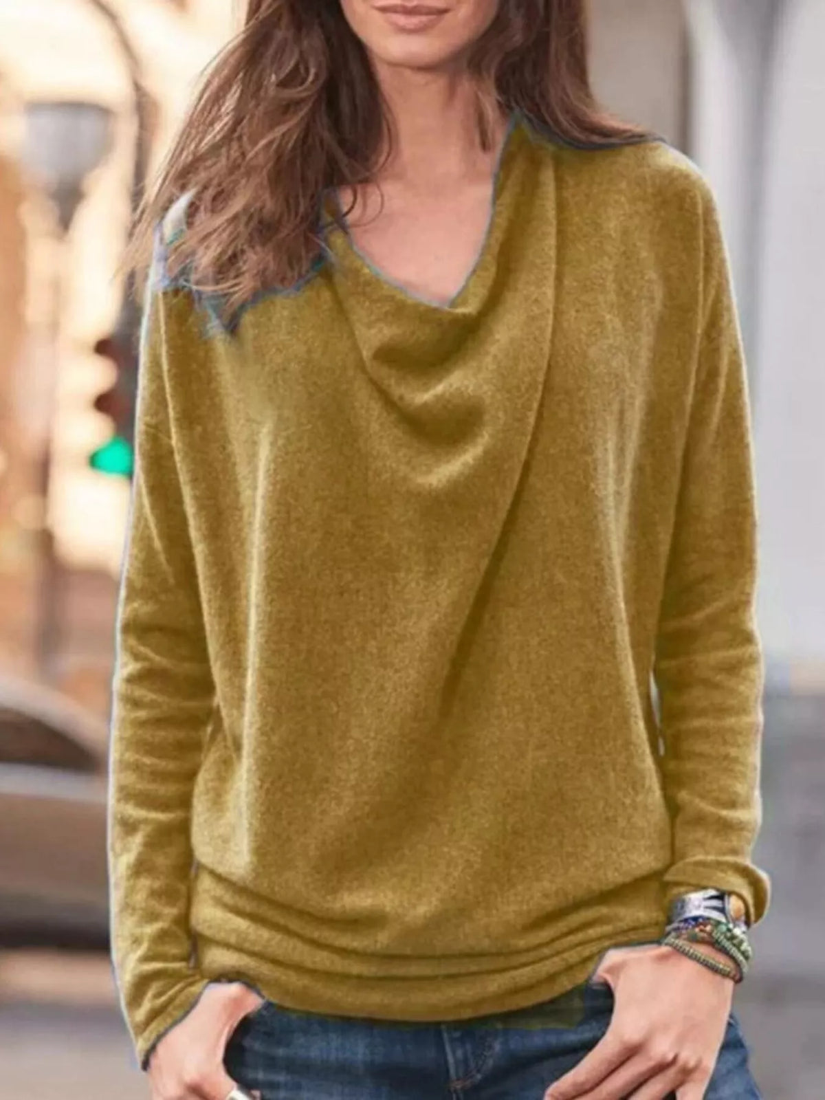 NEWYORKLISTED STYLE COLLECTION: Woman wearing a mustard yellow long-sleeve top with a blurred background