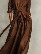 NEWYORKLISTED STYLE COLLECTION: Brown dress with a tie waist on a neutral background