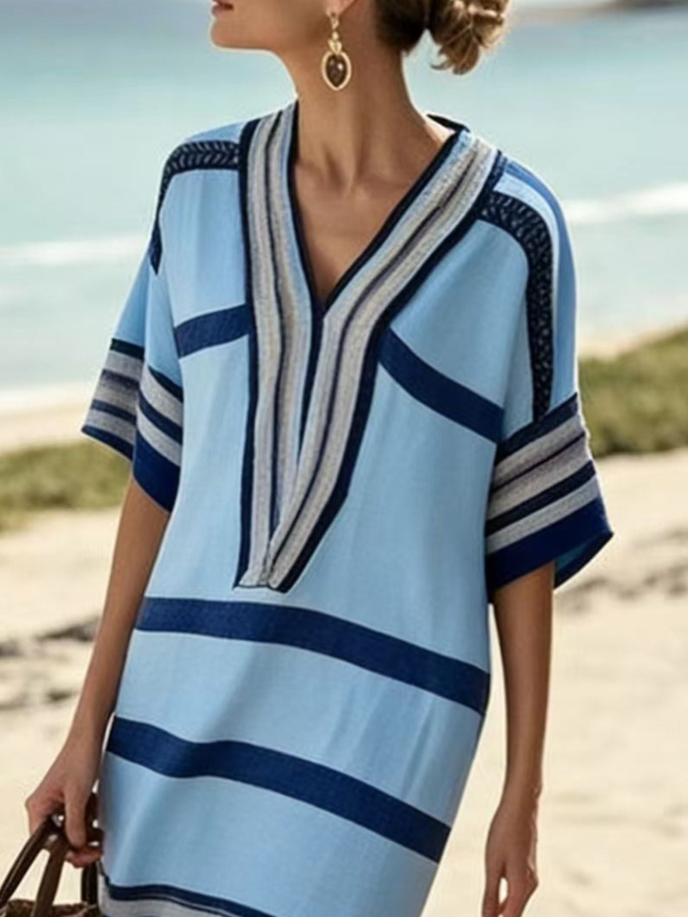 NEWYORKLISTED STYLE COLLECTION: Woman wearing a blue and white striped dress on a beach