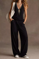 NEWYORKLISTED STYLE COLLECTION: Person wearing a black jumpsuit with a plain background