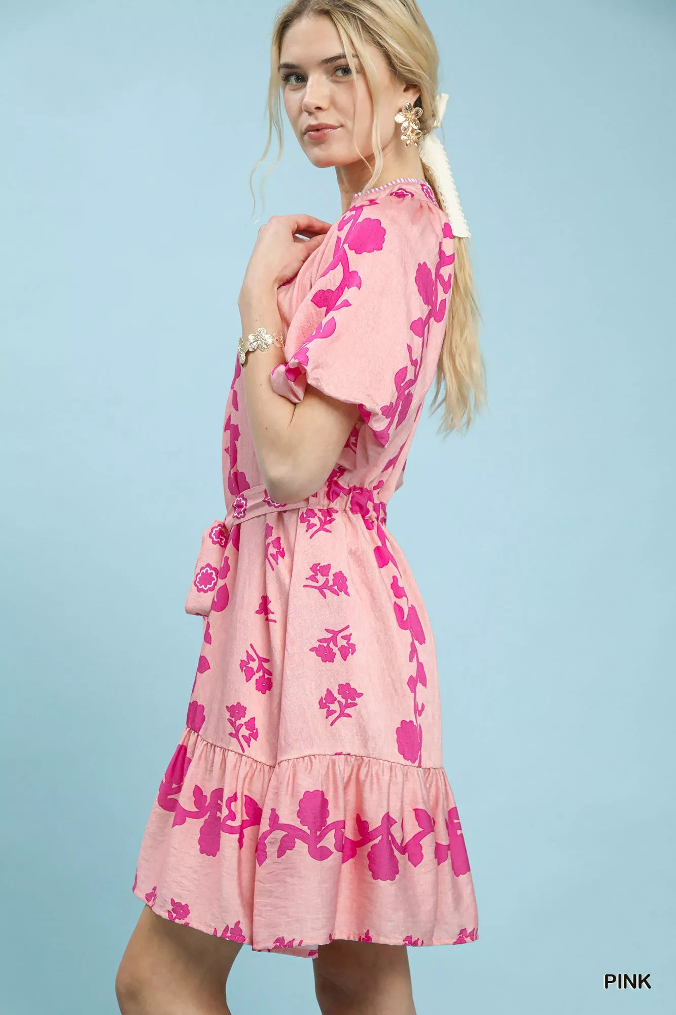 NEWYORKLISTED STYLE COLLECTION: Woman wearing a pink floral dress against a light blue background