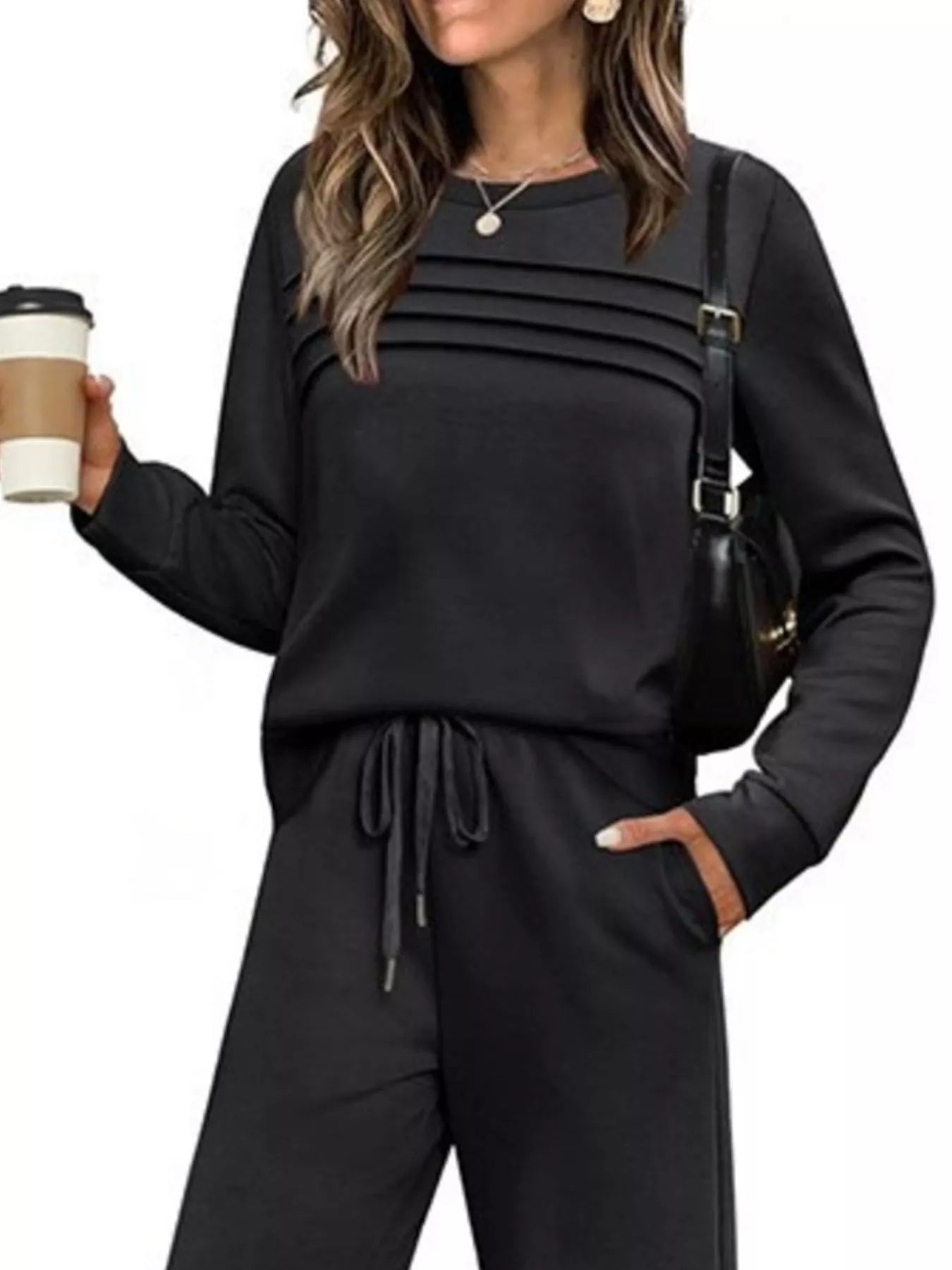 NEWYORKLISTED COMFORT COLLECTION: Woman wearing a black outfit holding a coffee cup on a white background