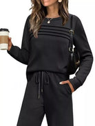 NEWYORKLISTED COMFORT COLLECTION: Woman wearing a black outfit holding a coffee cup on a white background