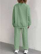 NEWYORKLISTED COMFORT COLLECTION: Person wearing a green textured sweater and pants set against a plain background