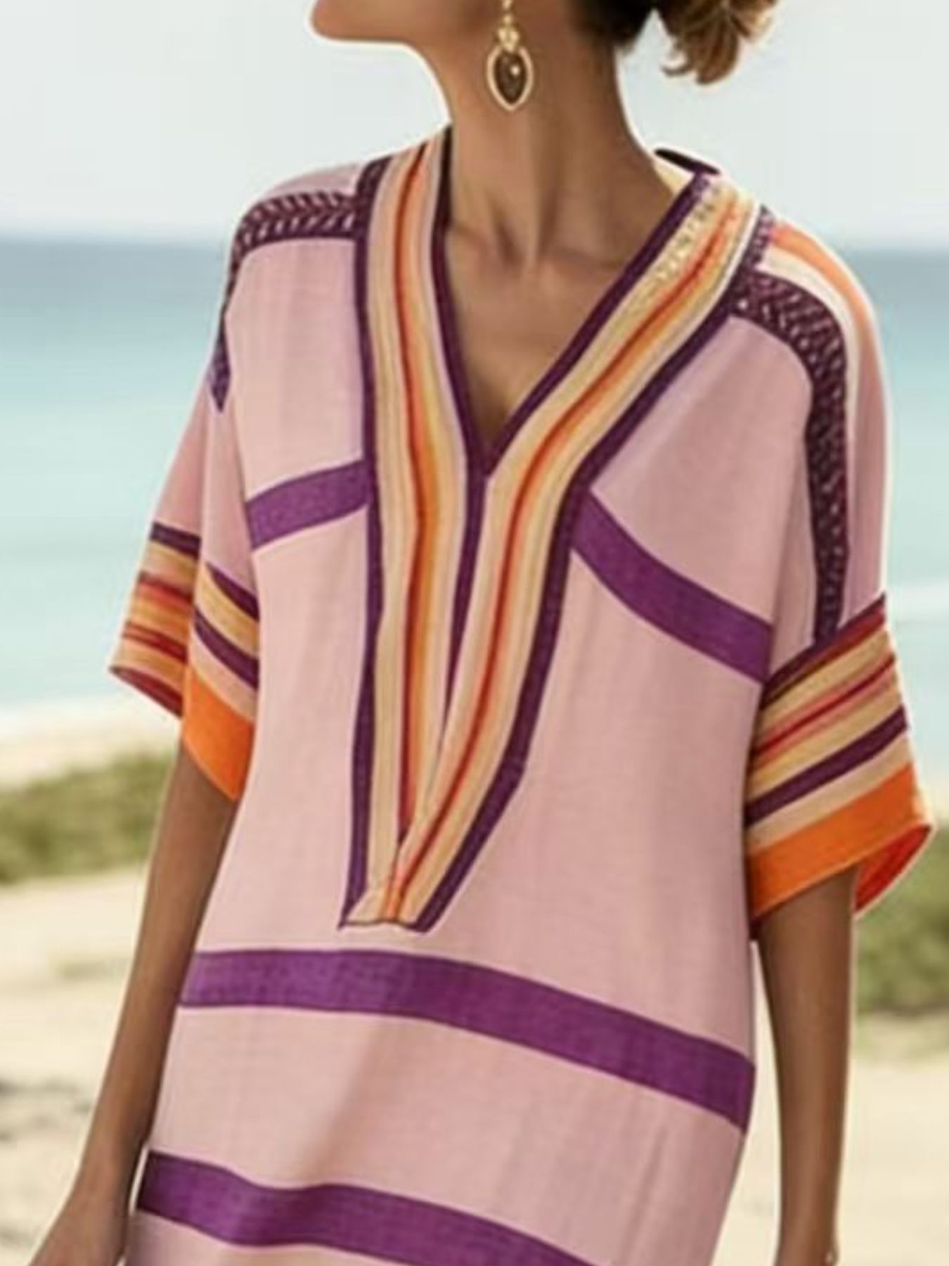 NEWYORKLISTED STYLE COLLECTION: Woman wearing a colorful striped top on a beach