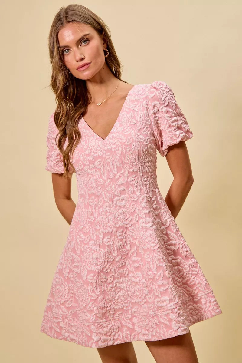 NEWYORKLISTED STYLE COLLECTION: Woman wearing a pink floral dress against a beige background