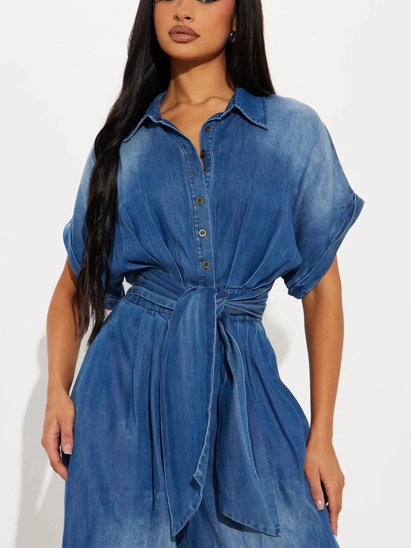 NEWYORKLISTED STYLE COLLECTION: Woman wearing a blue denim dress against a white background