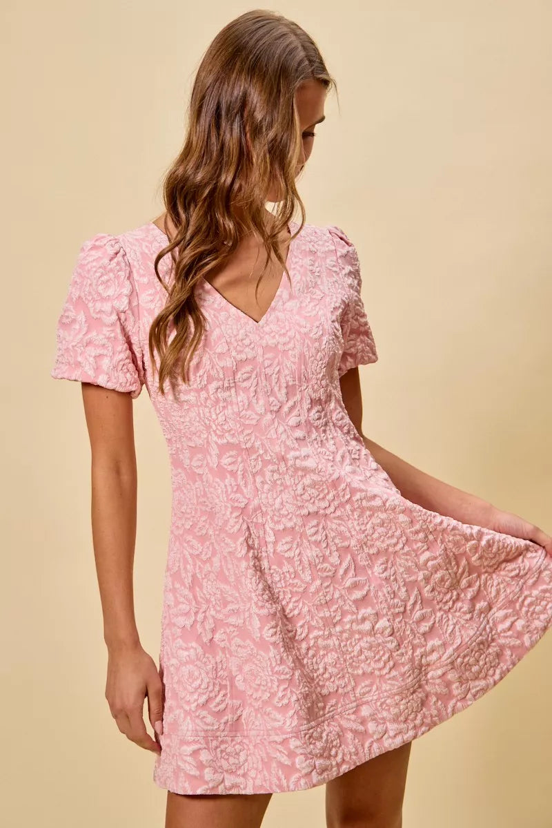 NEWYORKLISTED STYLE COLLECTION: Woman wearing a pink floral dress against a beige background