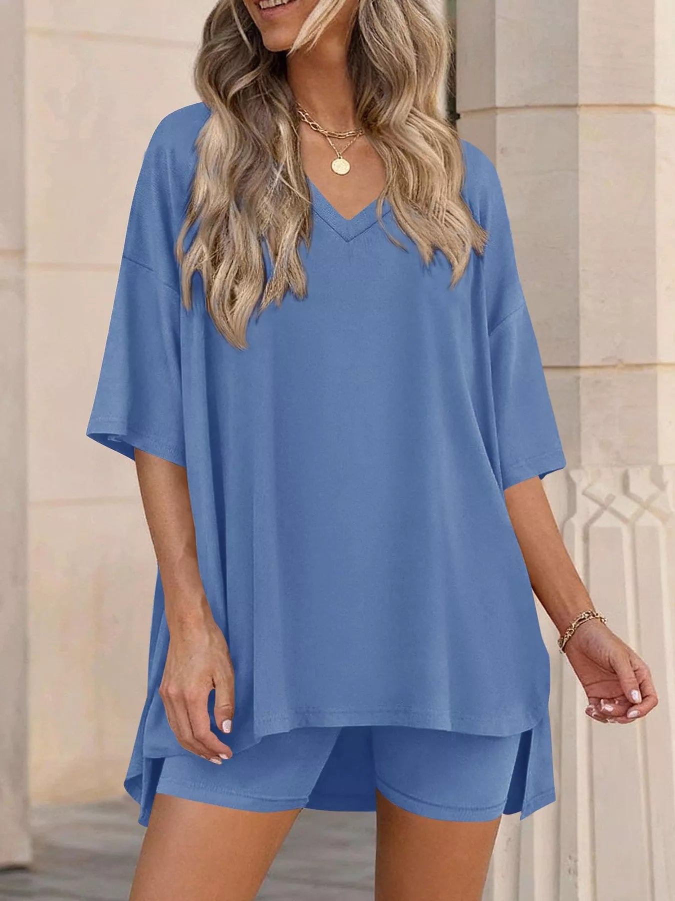 NEWYORKLISTED COMFORT COLLECTION: Woman wearing a blue outfit with a matching top and shorts in front of a beige wall.