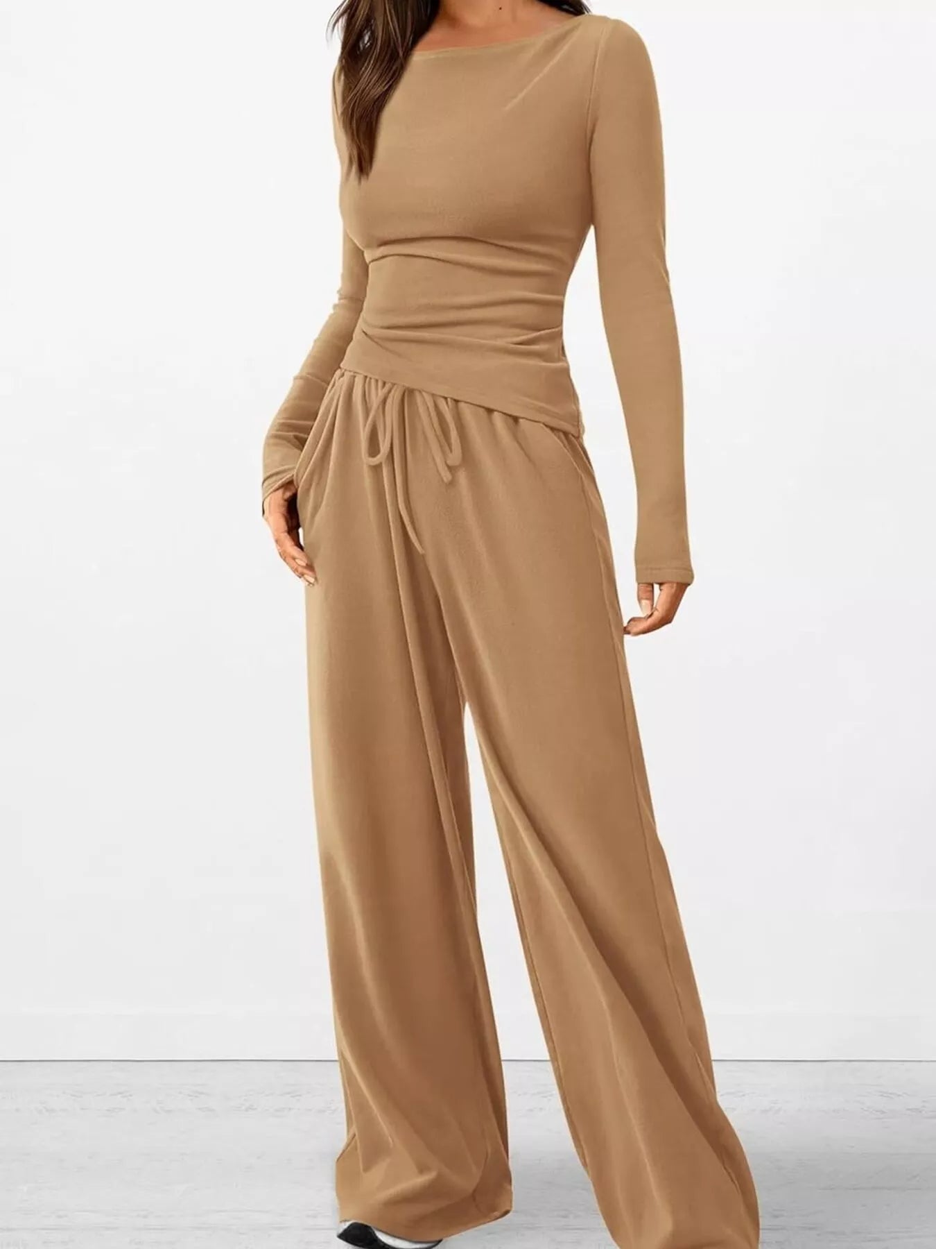 Brown jumpsuit with long sleeves and wide-leg pants on a white background