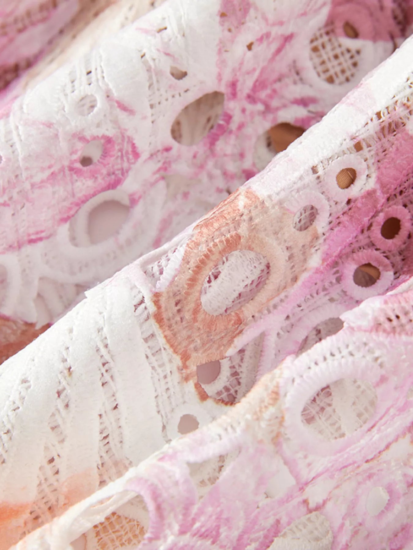 NEWYORKLISTED STYLE COLLECTION: Close-up of pink and white lace fabric with intricate patterns.