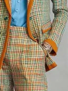 NEWYORKLISTED STYLE COLLECTION: A close-up of a men's plaid suit jacket and matching trousers with orange-brown trim, worn over a light blue button-up shirt.