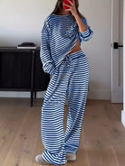 NEWYORKLISTED Comfort Collection: Person wearing a blue and white striped outfit in a room with wooden flooring and a black cabinet.