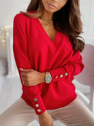 NEWYORKLISTED STYLE COLLECTION: Woman wearing a red sweater with gold buttons in an indoor setting