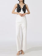 NEWYORKLISTED: Woman wearing a black and white outfit with a unique top design on a white background