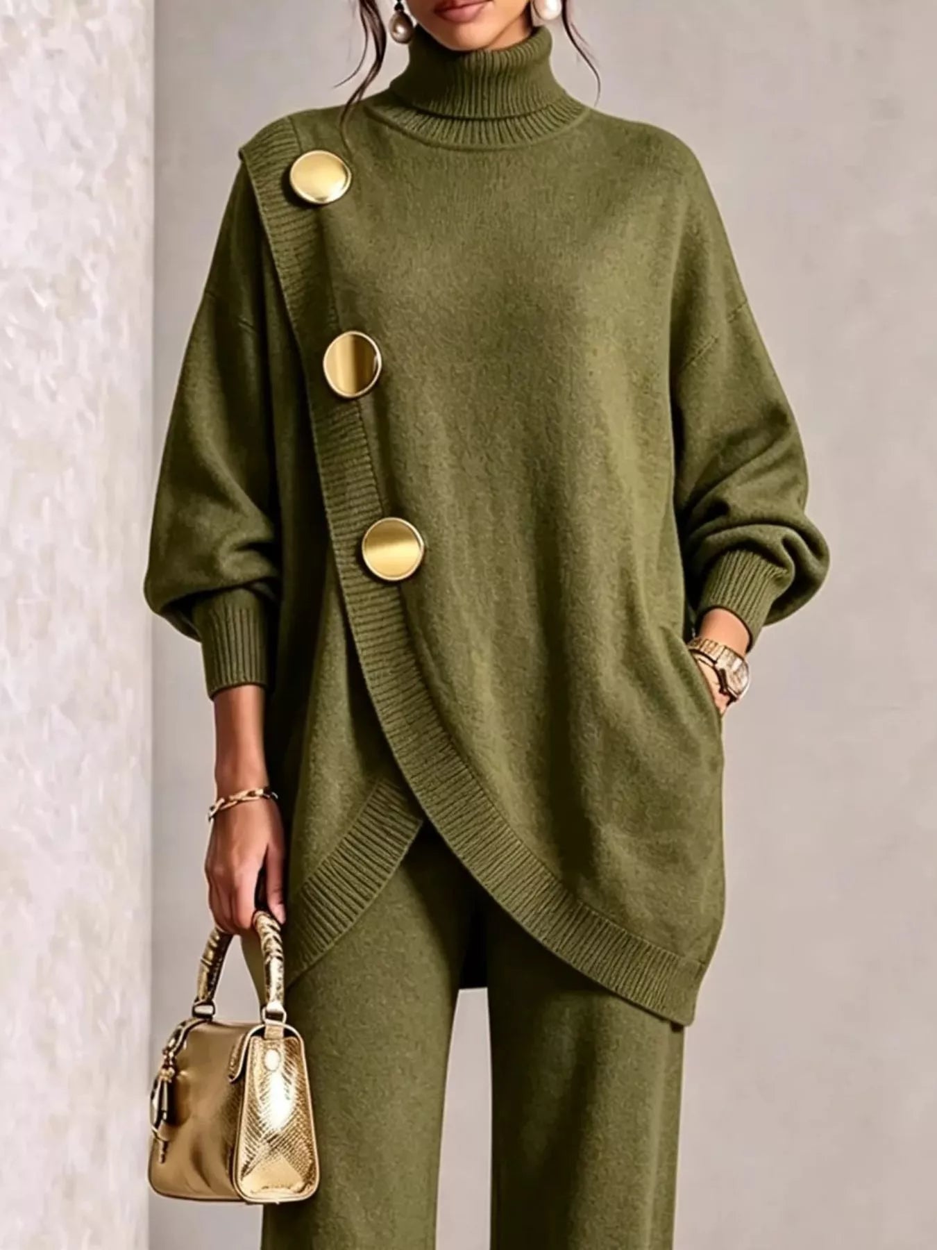 NEWYORKLISTED STYLE COLLECTION:  A woman models an olive green knit turtleneck sweater with oversized decorative gold buttons and matching wide-leg knit pants, holding a small metallic gold handbag against a neutral textured wall.