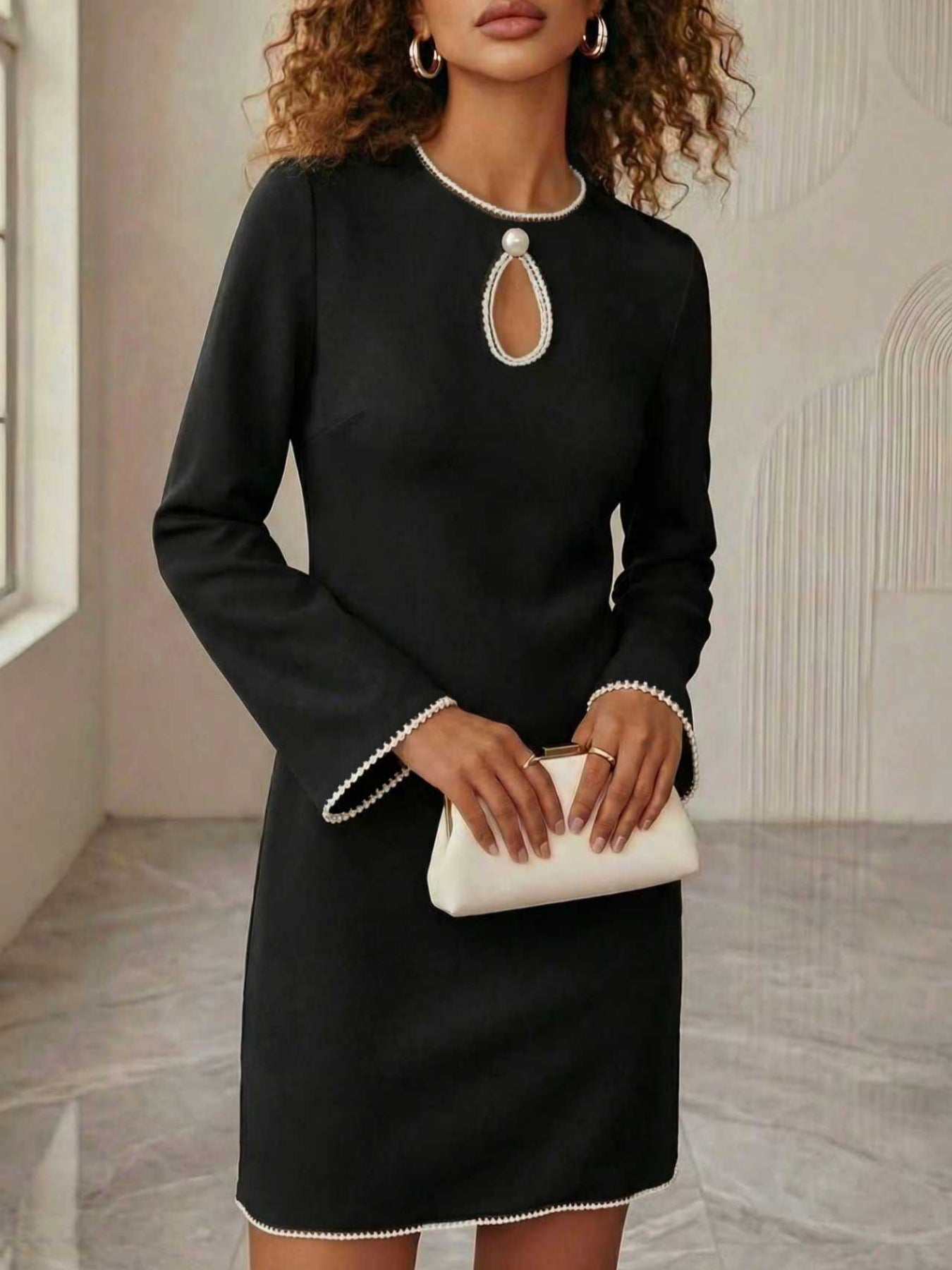 Woman wearing a NEWYORKLISTED STYLE COLLECTION keyhole pearl trim mini dress with elegant pearl neckline detail and polished evening style