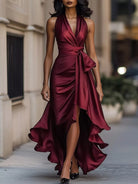 NEWYORKLISTED STYLE COLLECTION: Woman wearing a burgundy halter neck dress with a high slit on a city street.