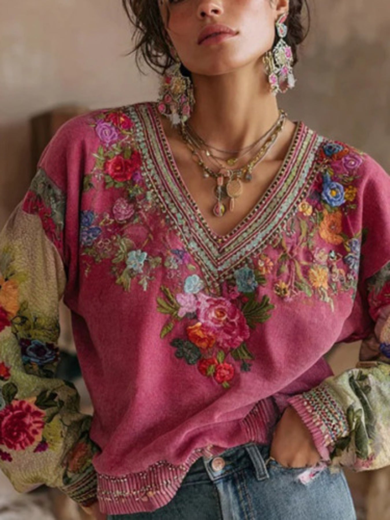 NEWYORKLISTED STYLE COLLECTION: Woman wearing a pink embroidered sweater with colorful floral patterns.