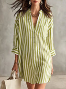 NEWYORKLISTED STYLE COLLECTION: A woman models a light green and white vertically striped linen shirt dress, holding a matching striped tote bag against a textured gray wall.