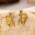NYLD Glamour Collection by NEWYORKLISTED: Gold earrings with gemstones on a stone surface
