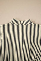 NEWYORKLISTED STYLE COLLECTION: Close-up of a black and white striped shirt collar on a beige background