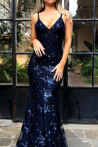 NEWYORKLISTED STYLE COLLECTION: Woman wearing a navy blue sequin dress standing in front of a glass door.