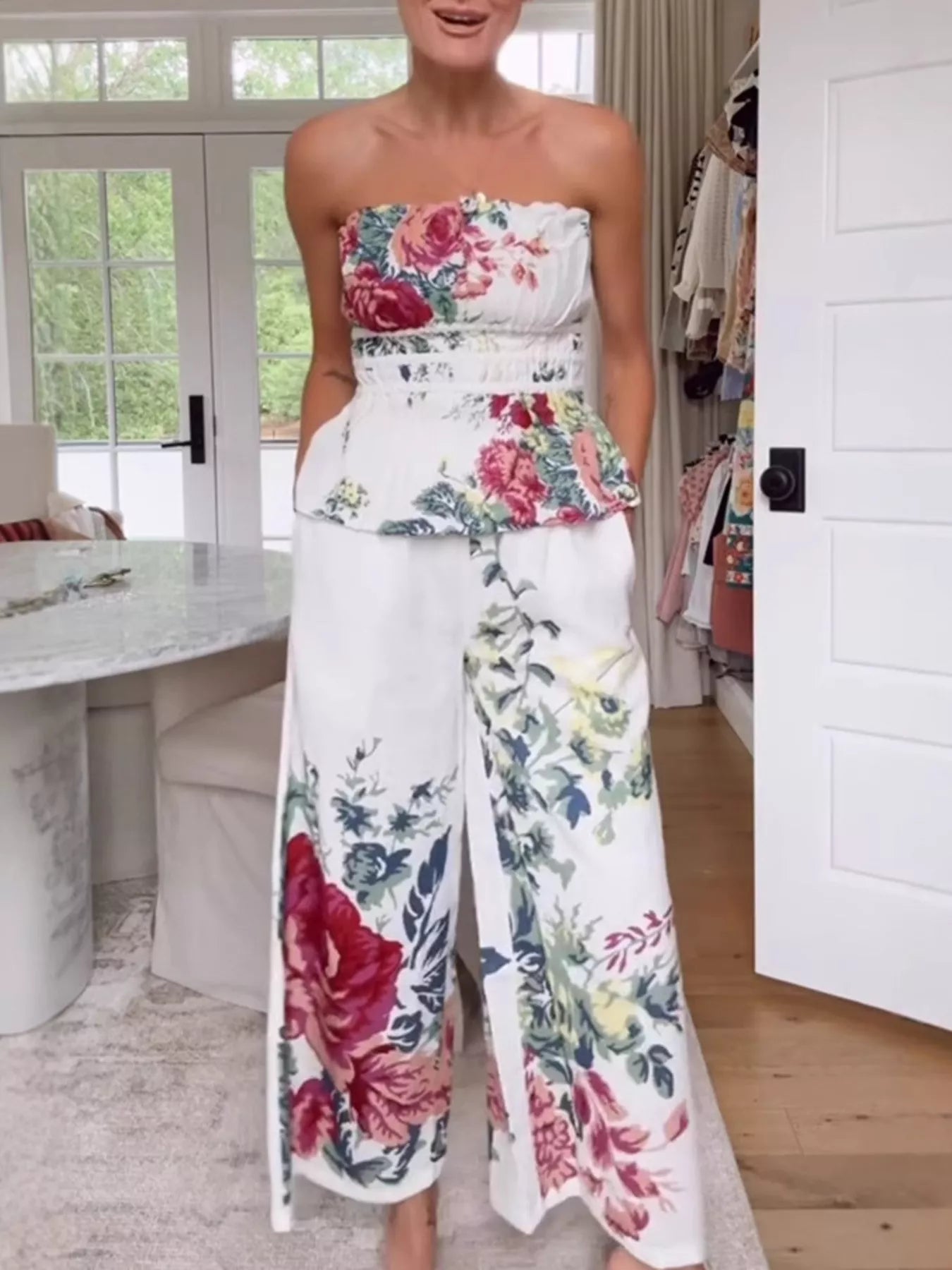 NEWYORKLISTED STYLE COLLECTION: Woman wearing a strapless floral top and wide-leg pants in a room with a desk and door.