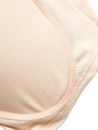 NEWYORKLISTED Intimate Apparel: Close-up of a beige bra strap on a white background