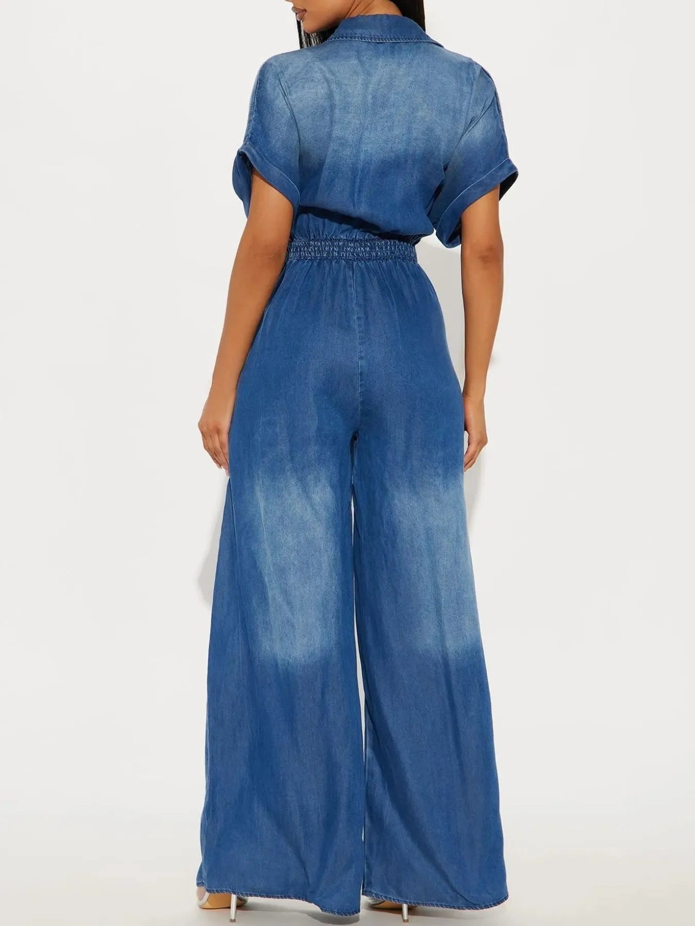 NEWYORKLISTED STYLE COLLECTION: Blue denim jumpsuit worn by a model on a white background