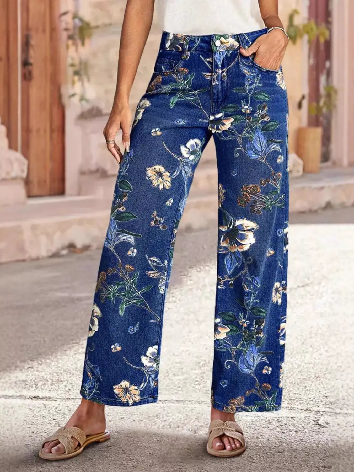 NEWYORKLISTED STYLE COLLECTION: Person wearing blue floral pants standing outdoors.