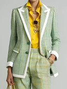 NEWYORKLISTED STYLE COLLECTION: A model wearing a green and white checkered blazer with white contrast piping, matching checkered trousers, a bright yellow shirt, and gold jewelry against a light gray background.