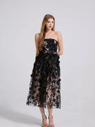 NEWYORKLISTED STYLE COLLECTION: Woman wearing a black floral strapless dress on a white background