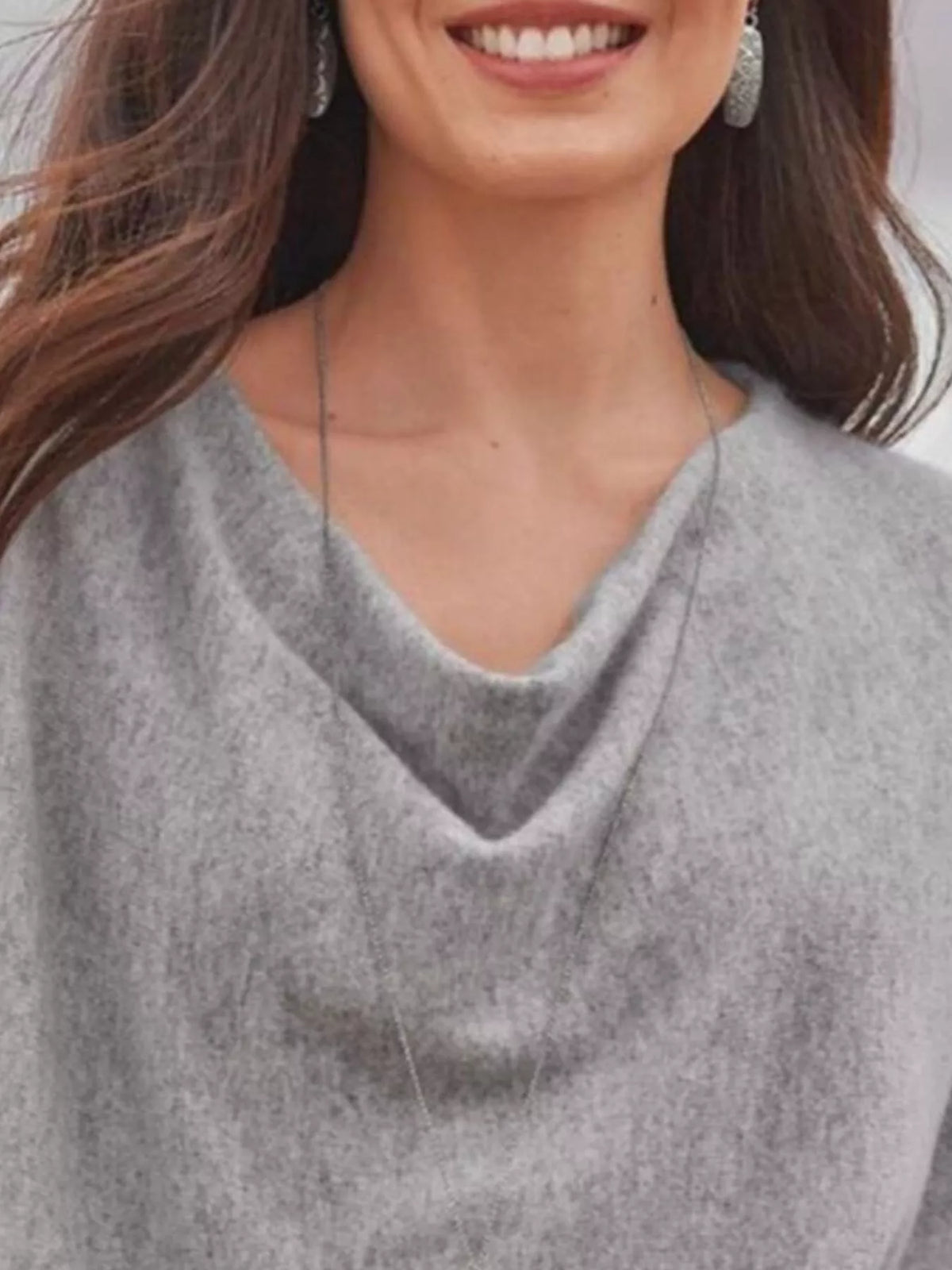 NEWYORKLISTED STYLE COLLECTION: Woman wearing a gray sweater with a draped neckline