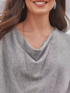 NEWYORKLISTED STYLE COLLECTION: Woman wearing a gray sweater with a draped neckline