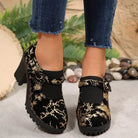 NEWYORKLISTED STYLE COLLECTION: Black floral embroidered boots worn with rolled-up jeans on a neutral background