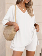 NEWYORKLISTED COMFORT COLLECTION: Woman wearing a white outfit with a straw bag against a neutral background