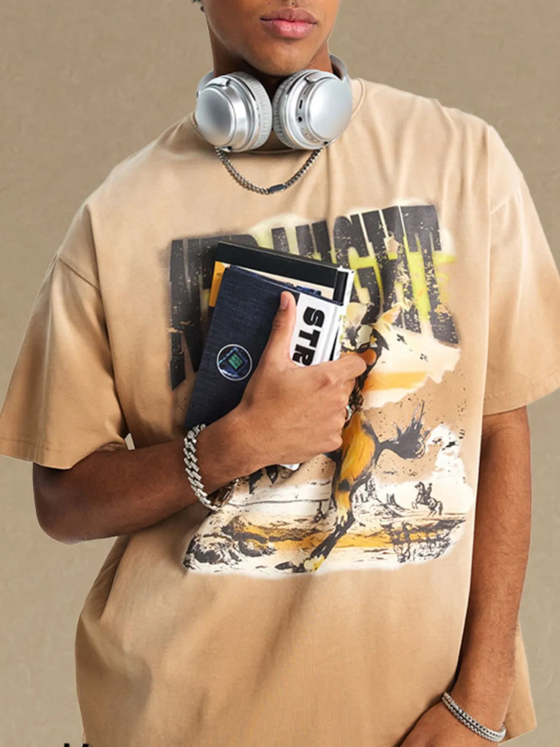 NEWYORKLISTED ATLAS MEN'S COLLECTION: Person wearing a beige t-shirt with graphic design, holding a phone case, on a beige background