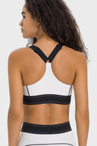 NEWYORKLISTED ACTIVEWEAR COLLECTION: Person wearing a black and white sports bra on a plain background